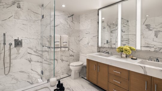 primary bathrooms with white marble and custom oak vanities