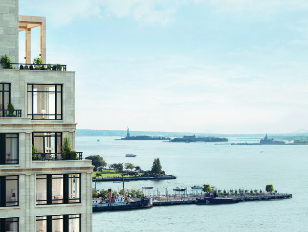 View of the Hudson River with the Statue of Liberty in the distance and a modern white building in the foreground
