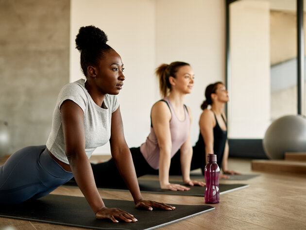 Three women in a yoga studio in upward-facing dog position