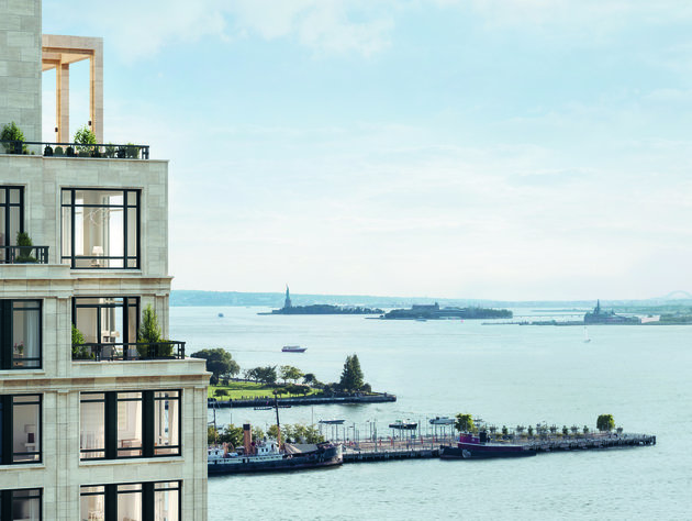View of the Hudson River with the Statue of Liberty in the distance and a modern white building in the foreground